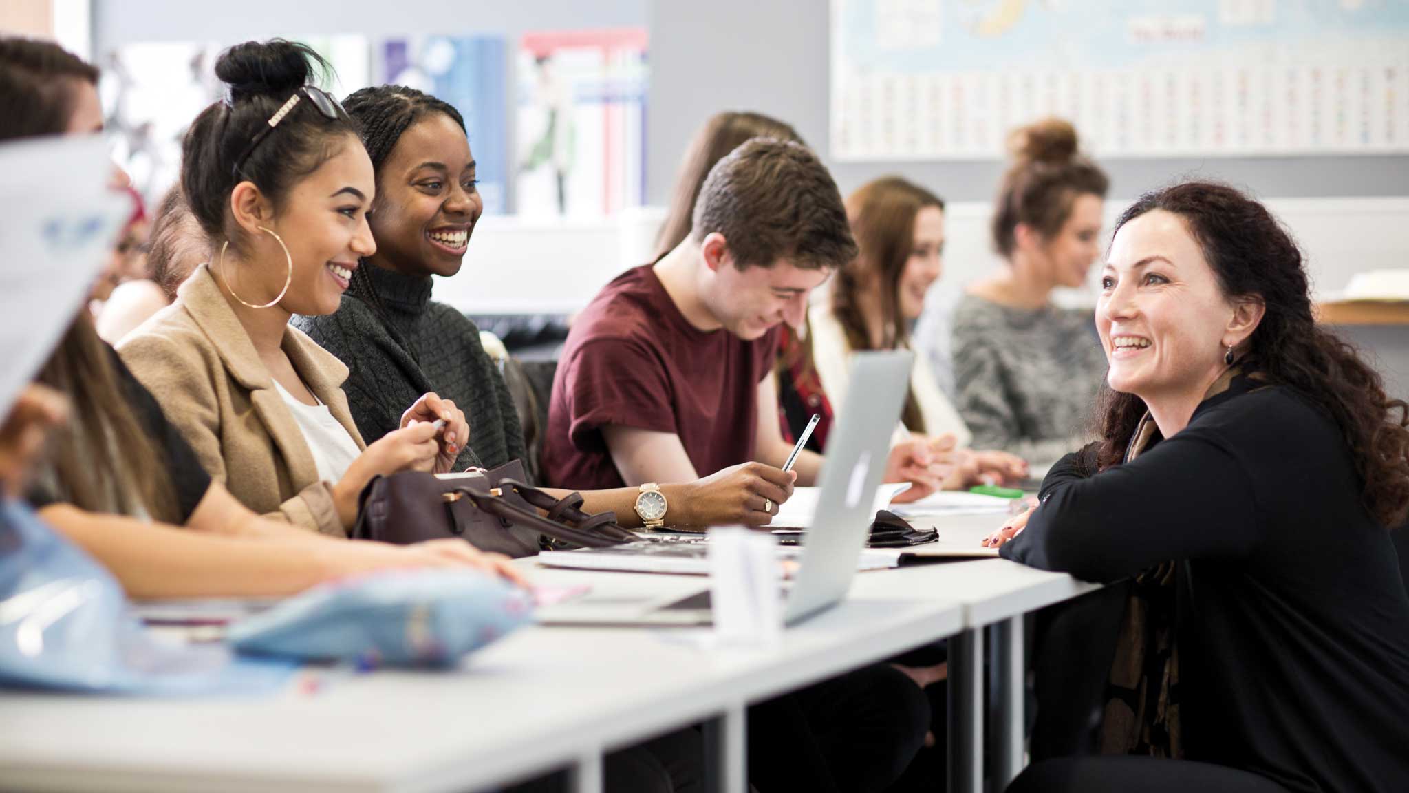 Four students sat at a table listening to their lecturer
