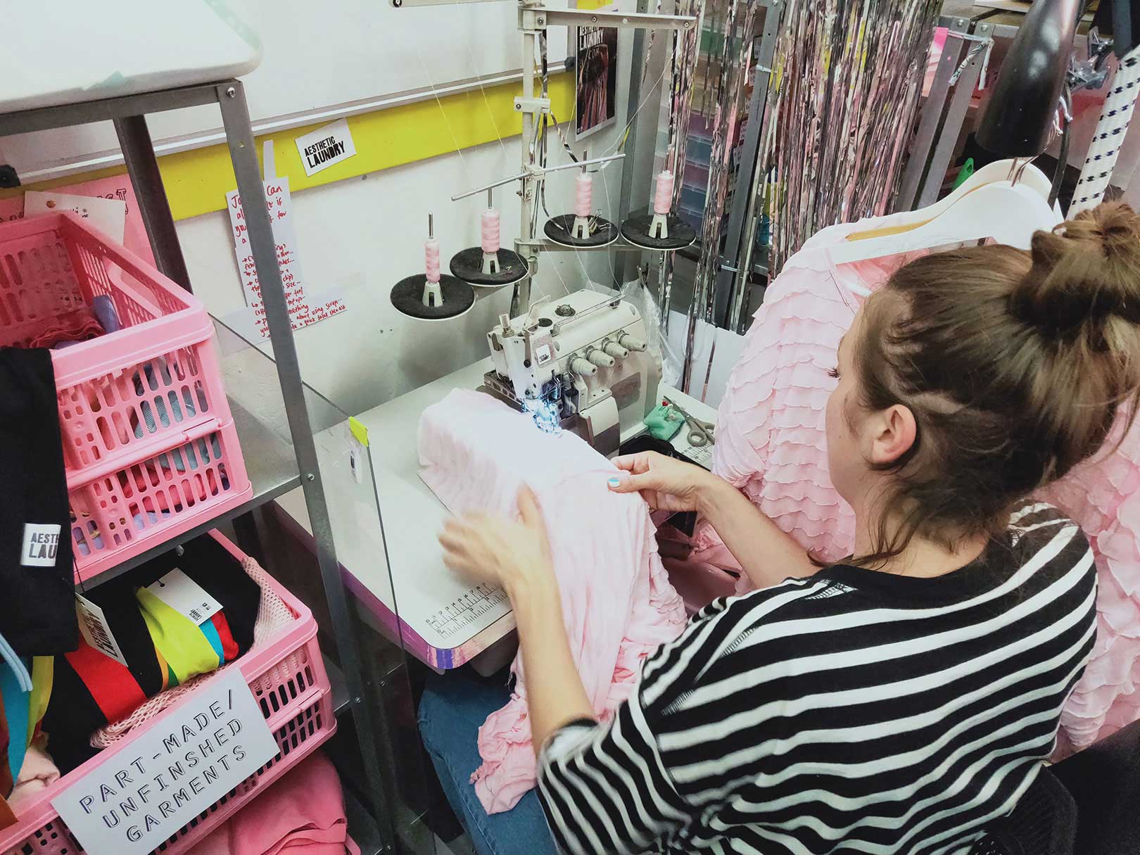 Heidi May sewing clothes in her design studio