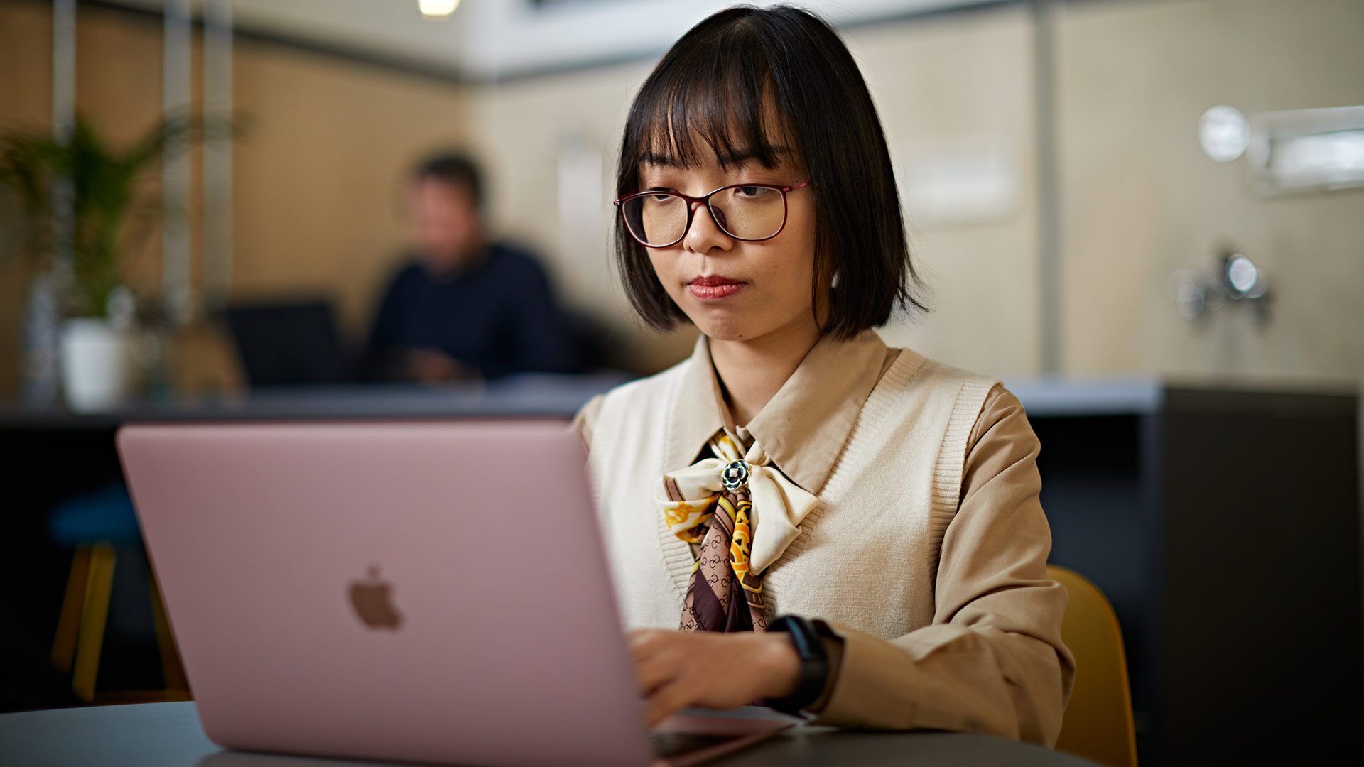 A student working on a laptop in a cafe.