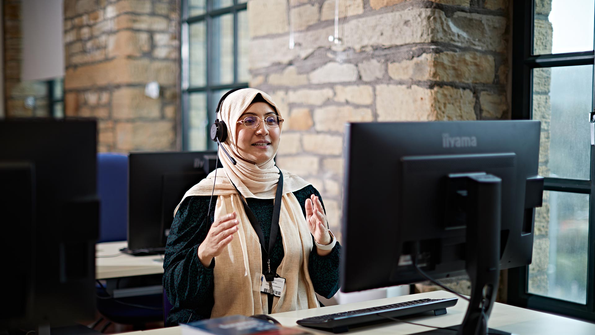 An academic sat at a computer, delivering an online session.