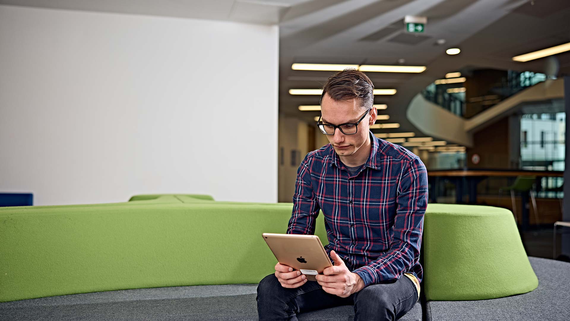 A student looking down at a tablet device.