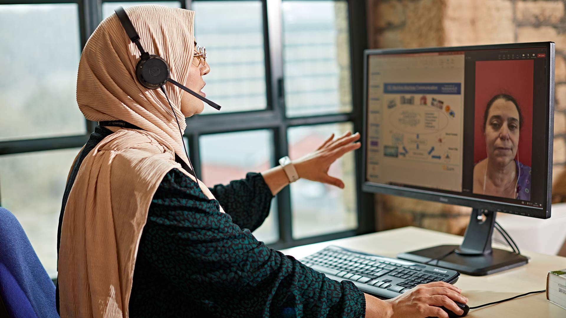 An academic delivering an online session to a student who is visible on screen.