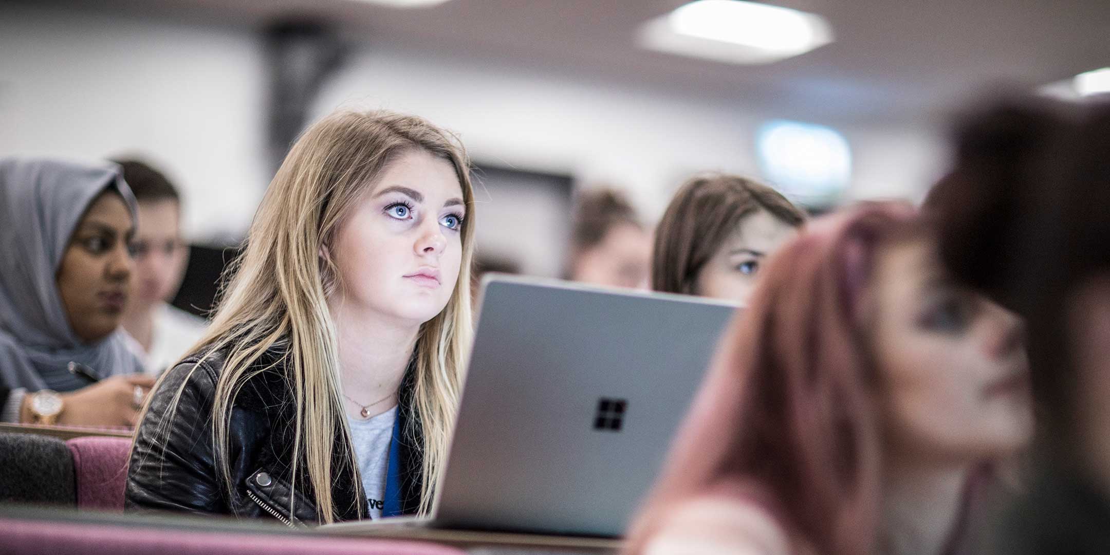 female student in lecture with Macbook
