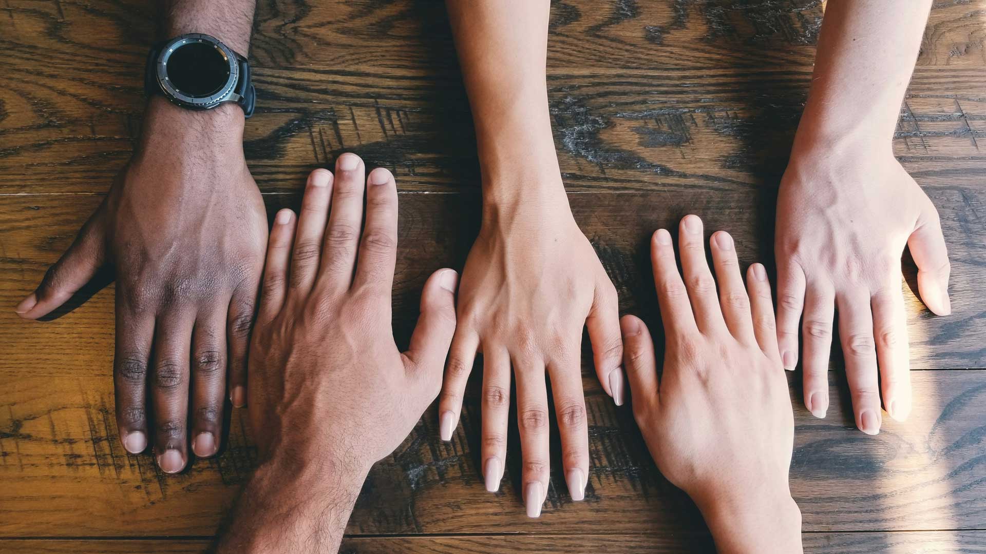 Hands grouped together face down on table