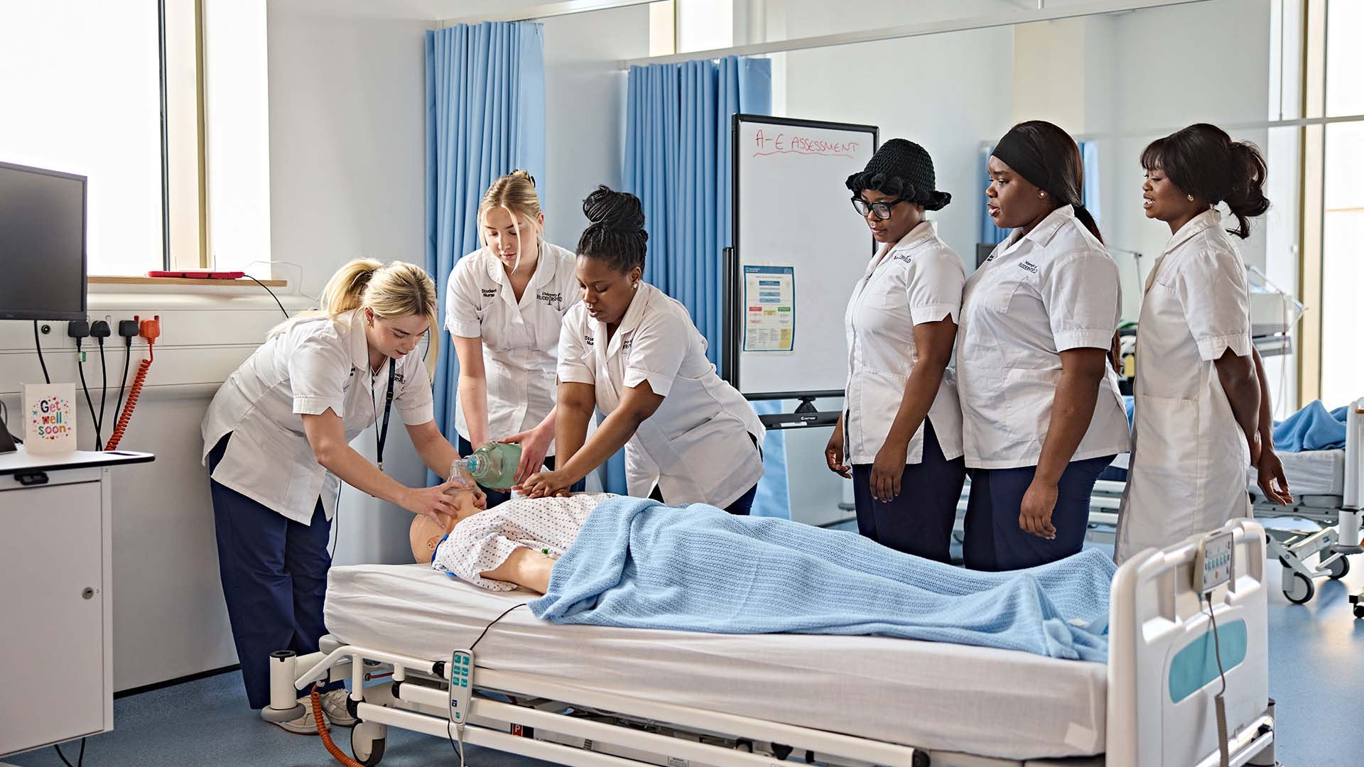 Nursing students collaborating on helping a patient