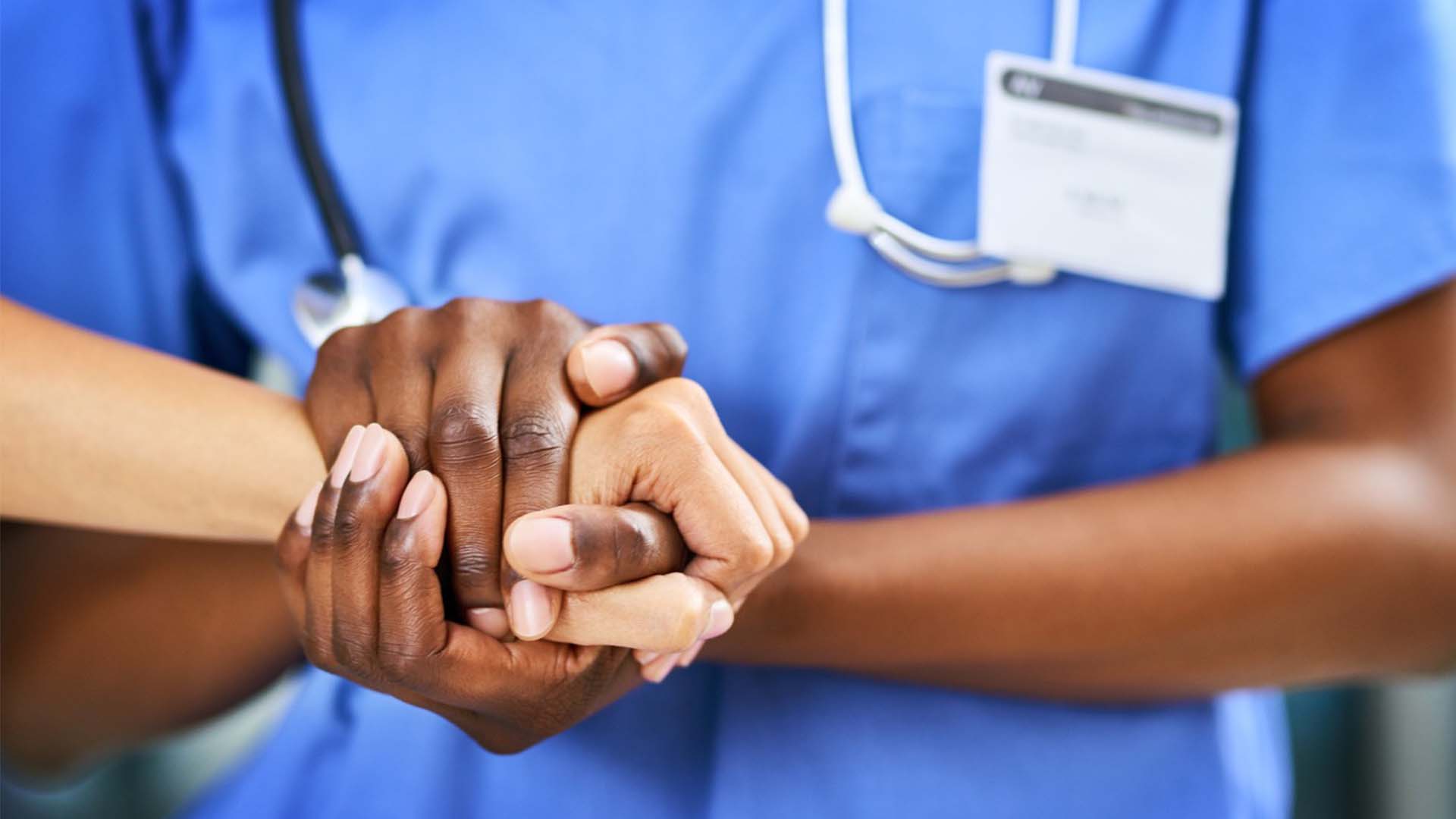 Nurse holding patients hand
