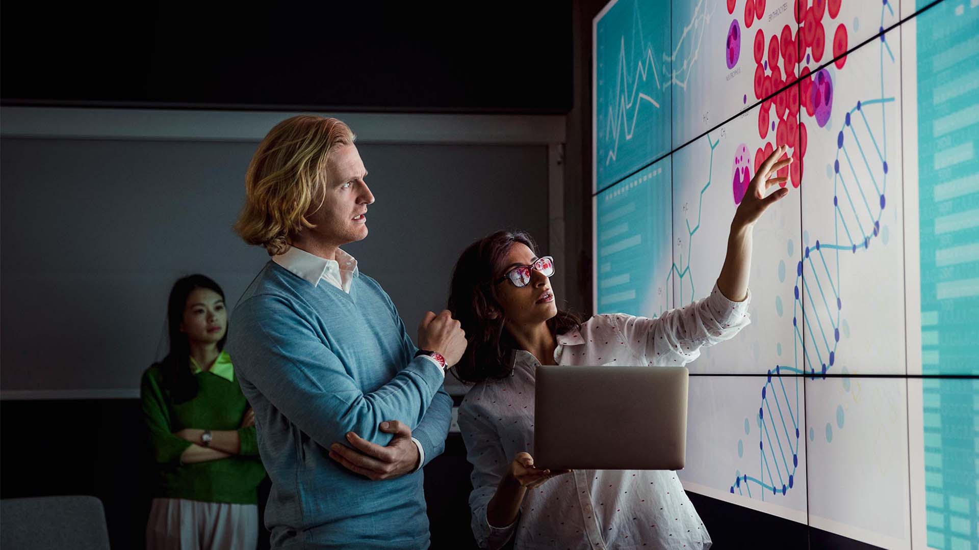 Two nursing researchers looking at medical data on a large screen