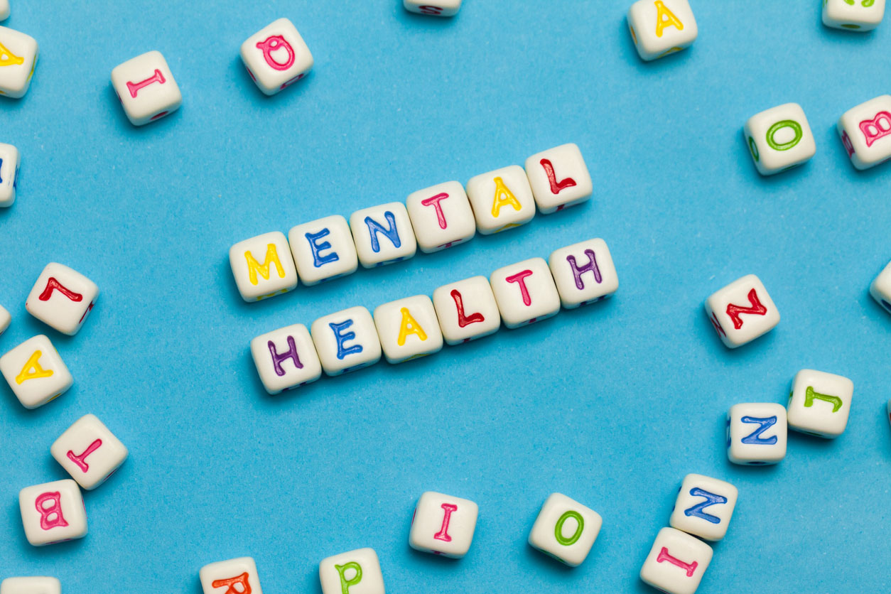 The words 'mental health' spelled out using colourful blocks on a pale blue background
