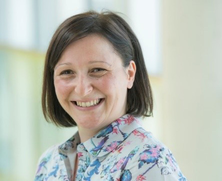 Dr Lynne Calman, wearing a floral shirt and smiling.