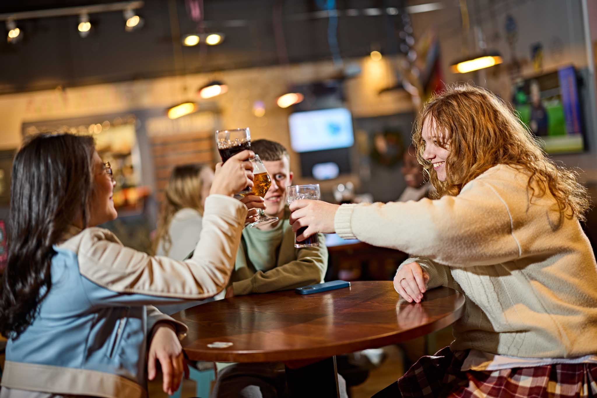 Students sitting round a table enjoying a drink