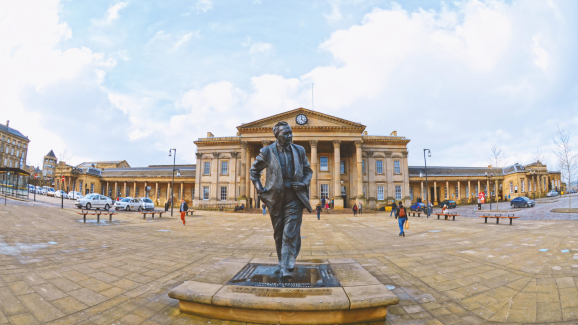 A wide angle view of the Harold Wilson statue outside the railway station