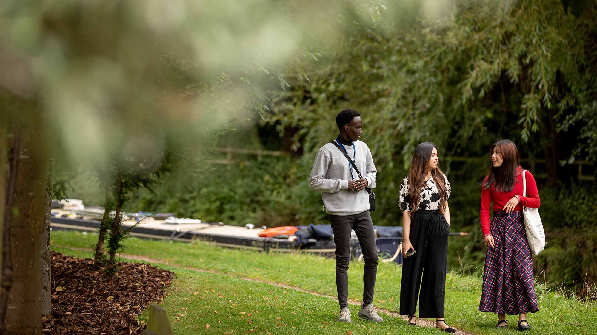 Students walk together along the canal at the University of Huddersfield campus