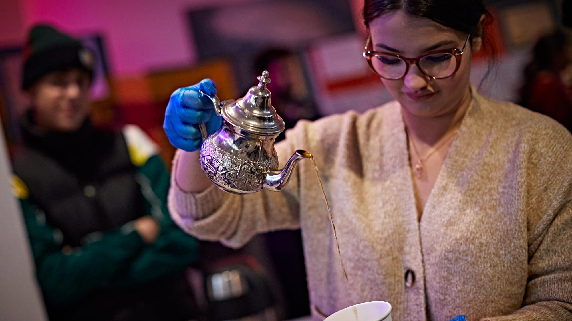 A student pours a traditional tea pot at the Global Campus Tea Party. 
