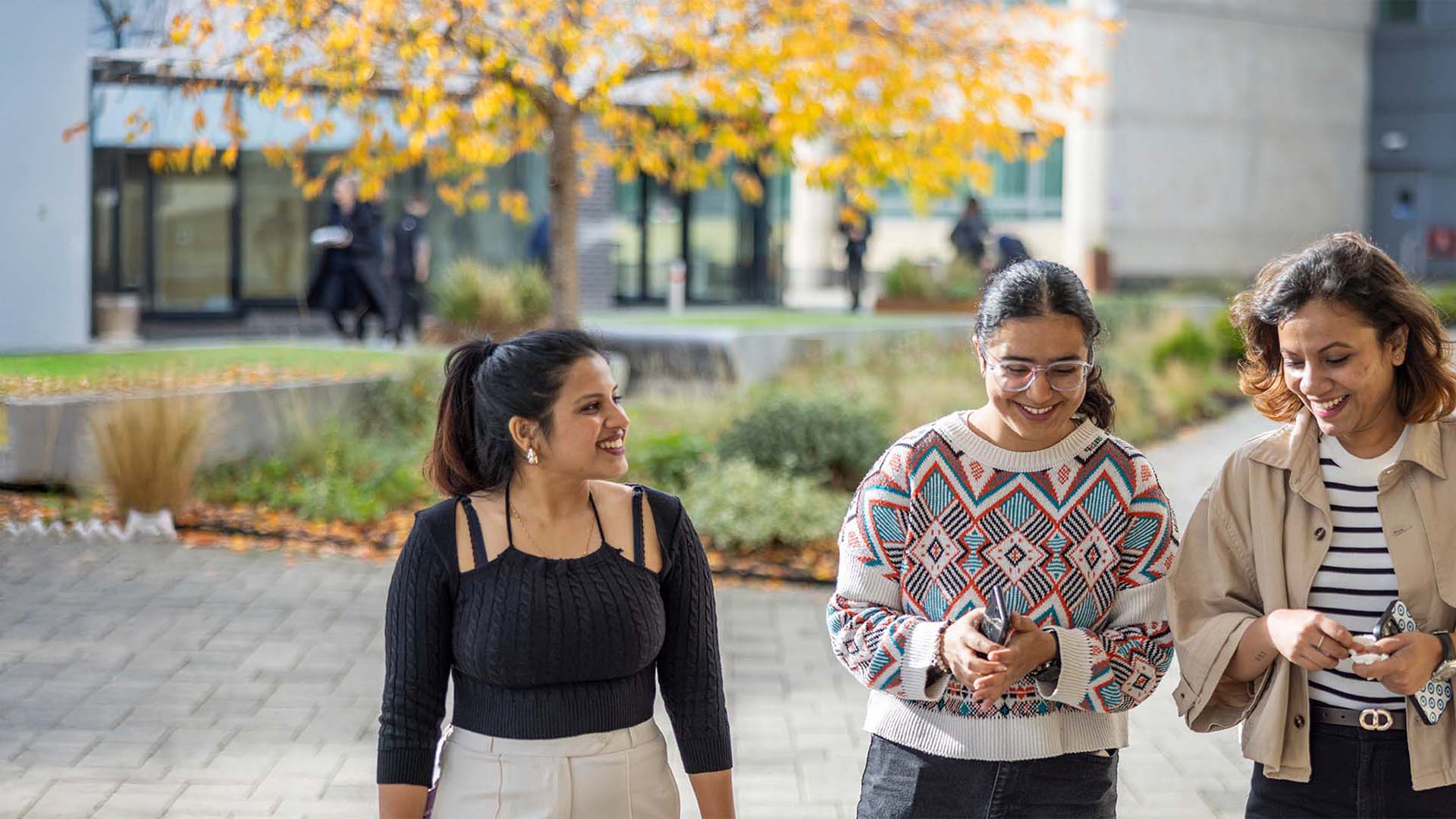 Three students smiling on campus