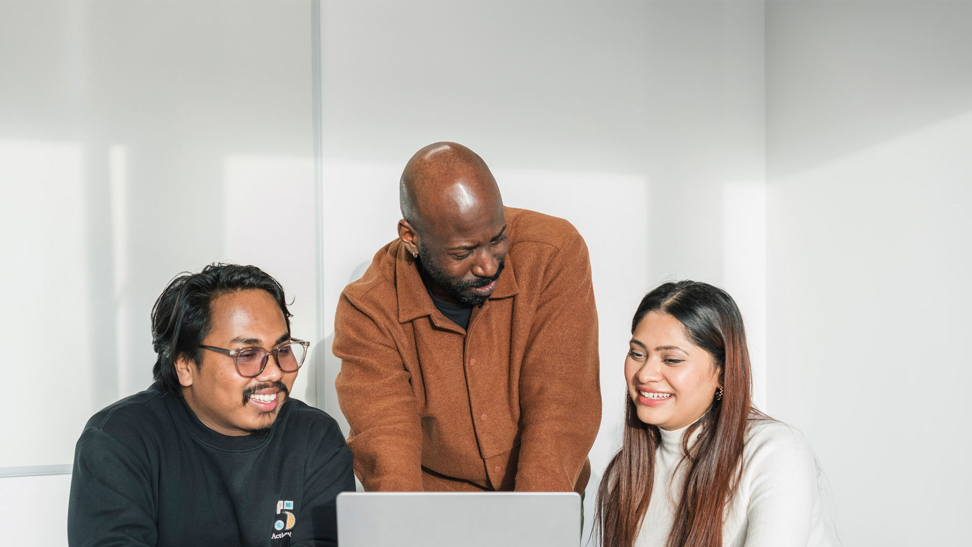 Students working with academic on project on computer