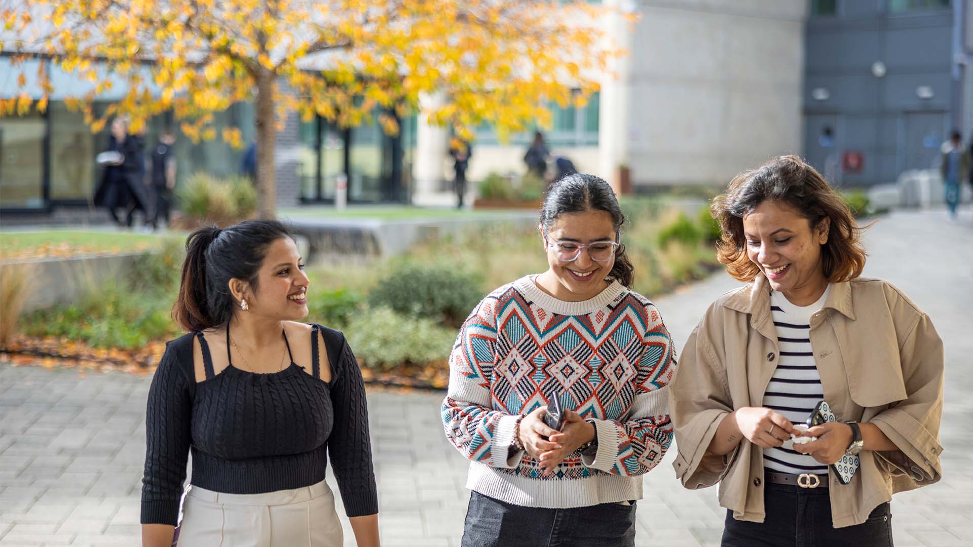 Three students smiling on campus