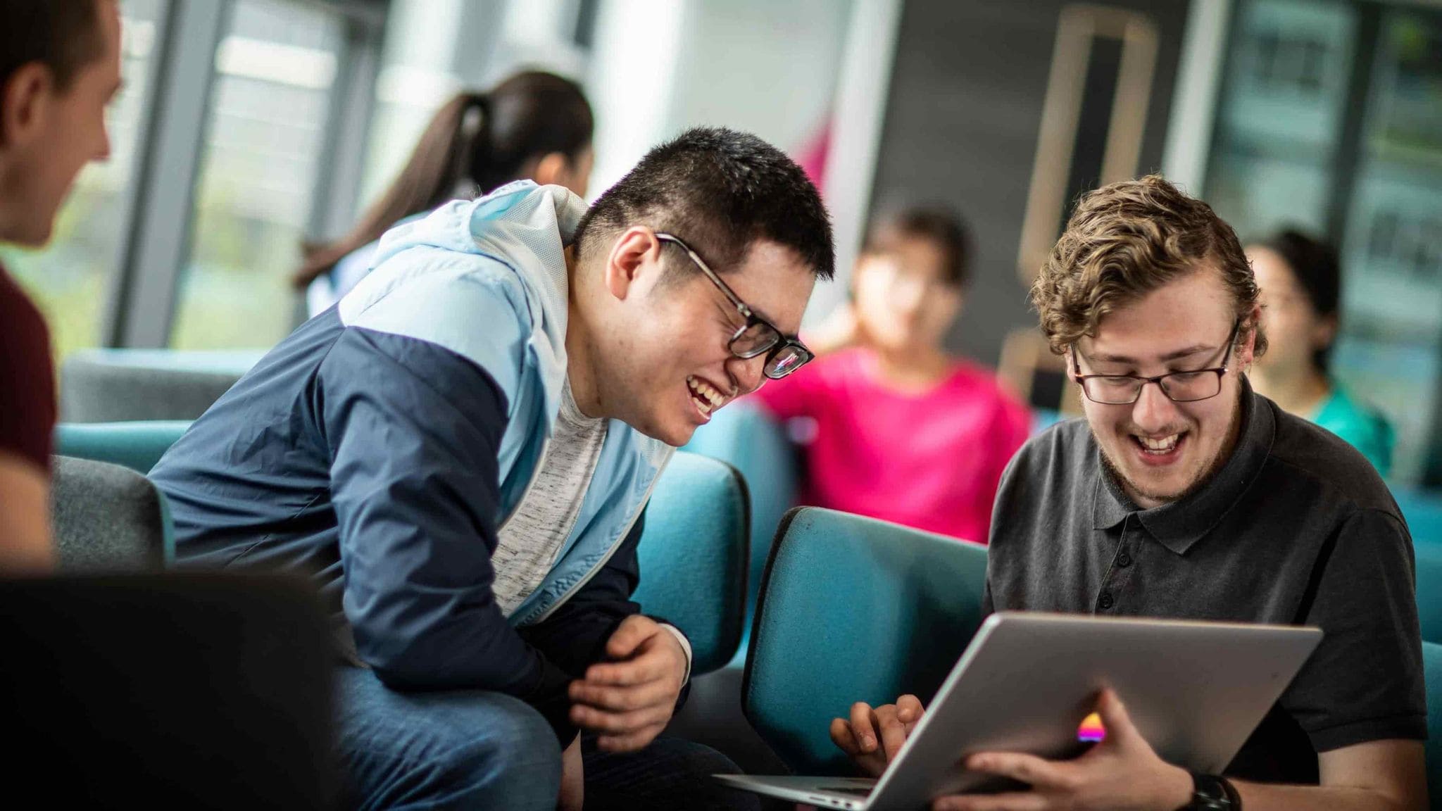 Two students sat looking at a laptop.