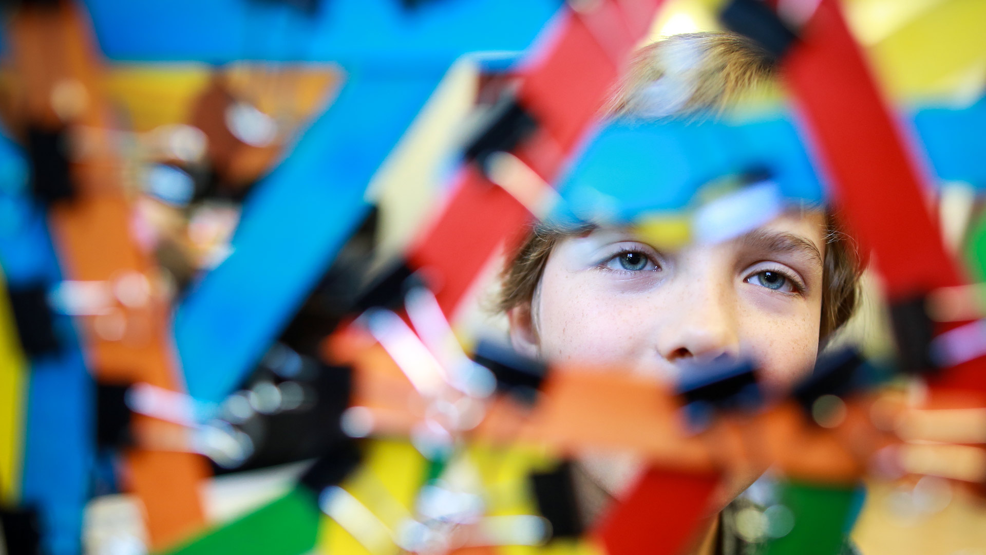 Child looking through colourful design