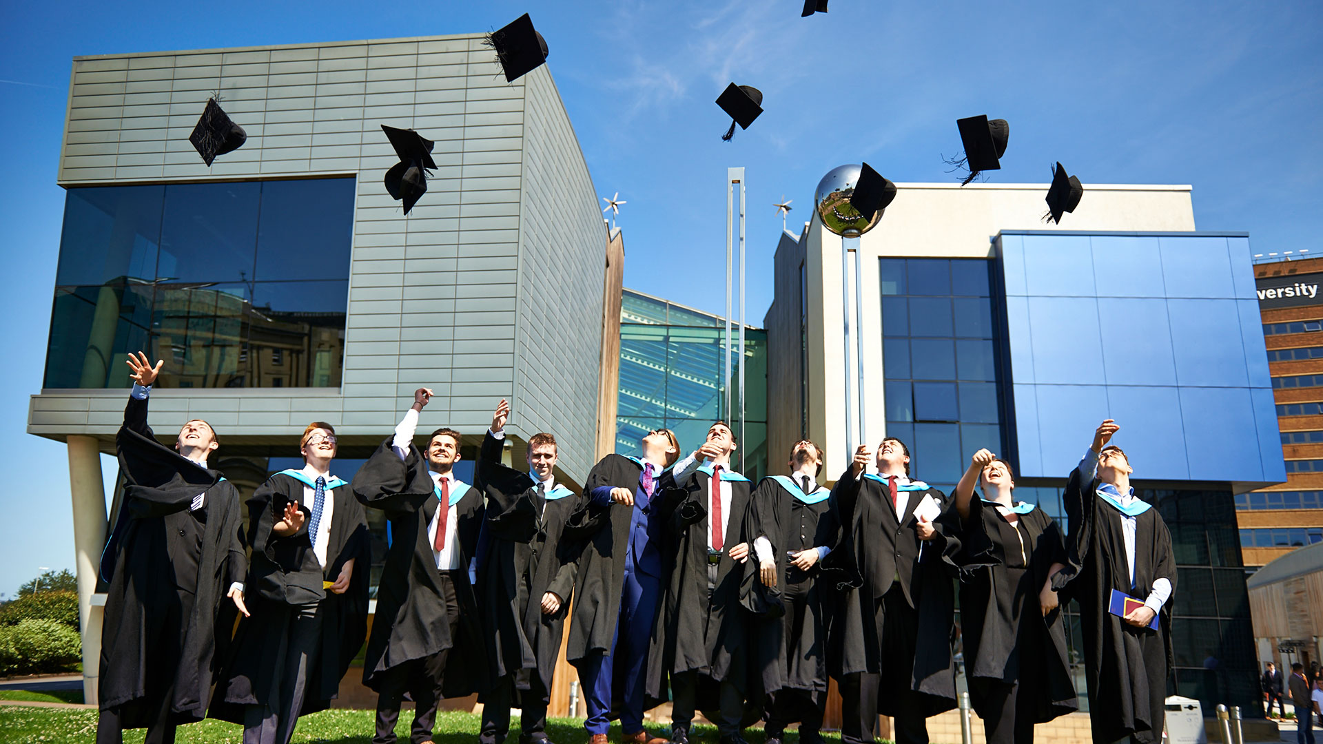 image of graduates throwing caps on graduation