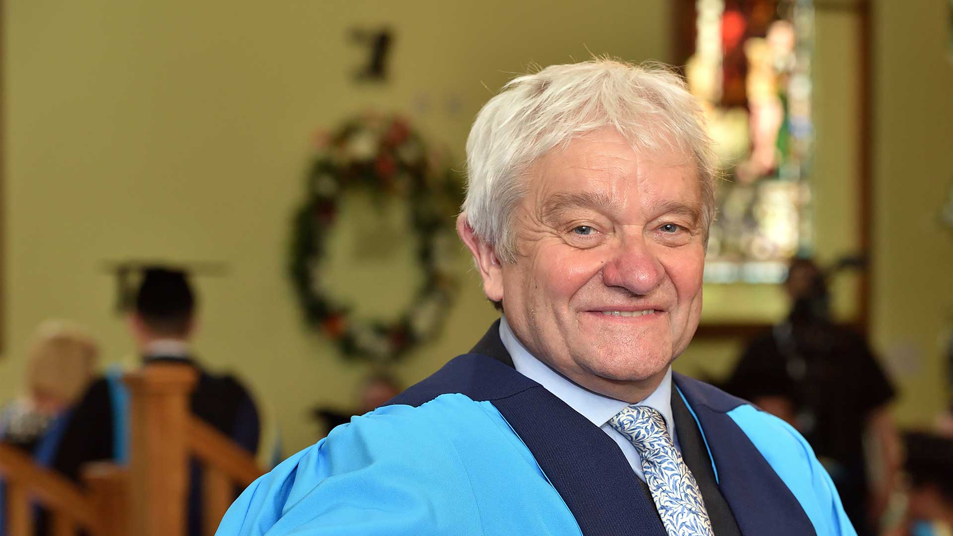 Sir Paul Nurse sitting in a graduation ceremony