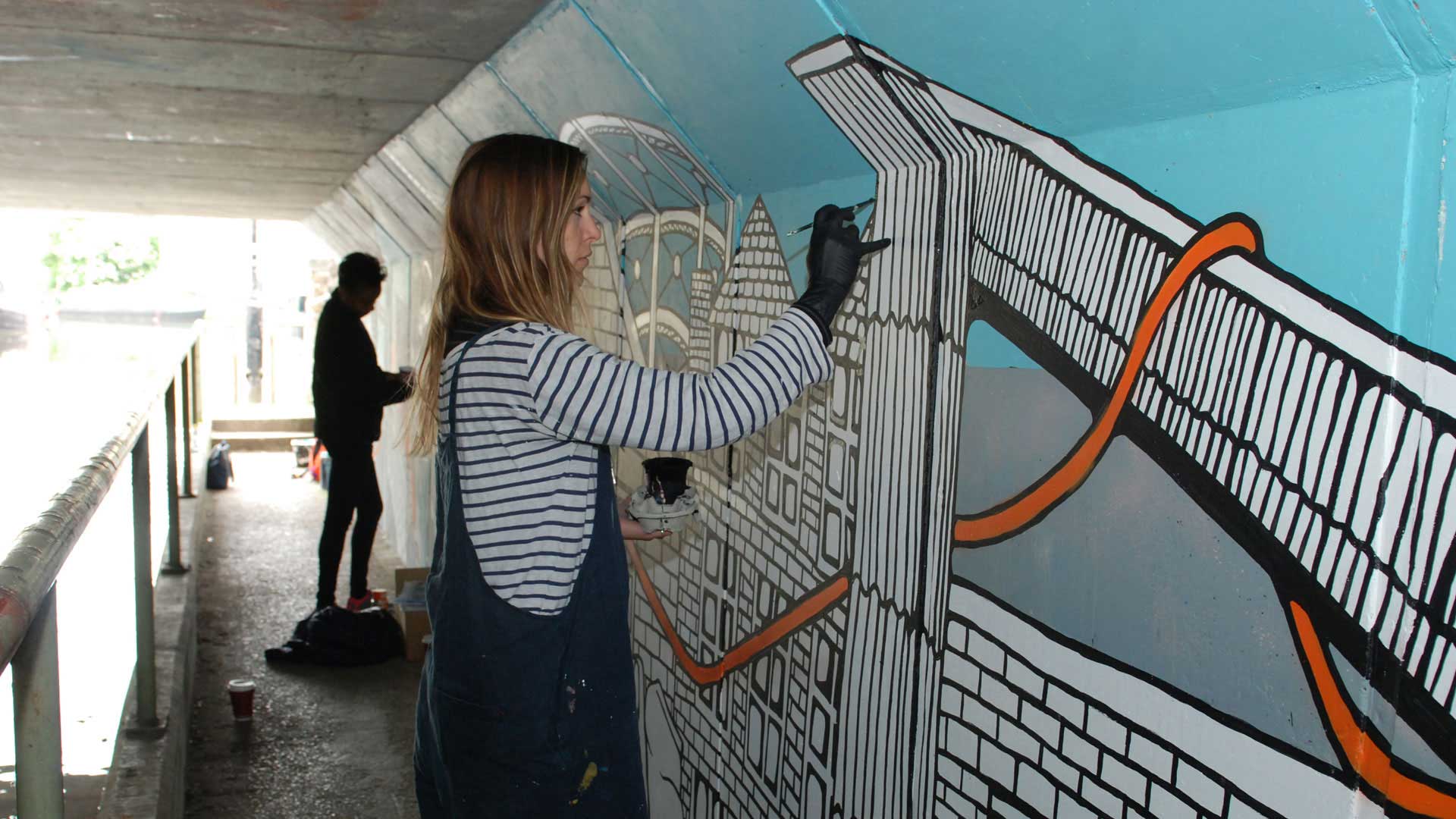professional street artist Jo Peel painting canal bridge on the Huddersfield Narrow Canal