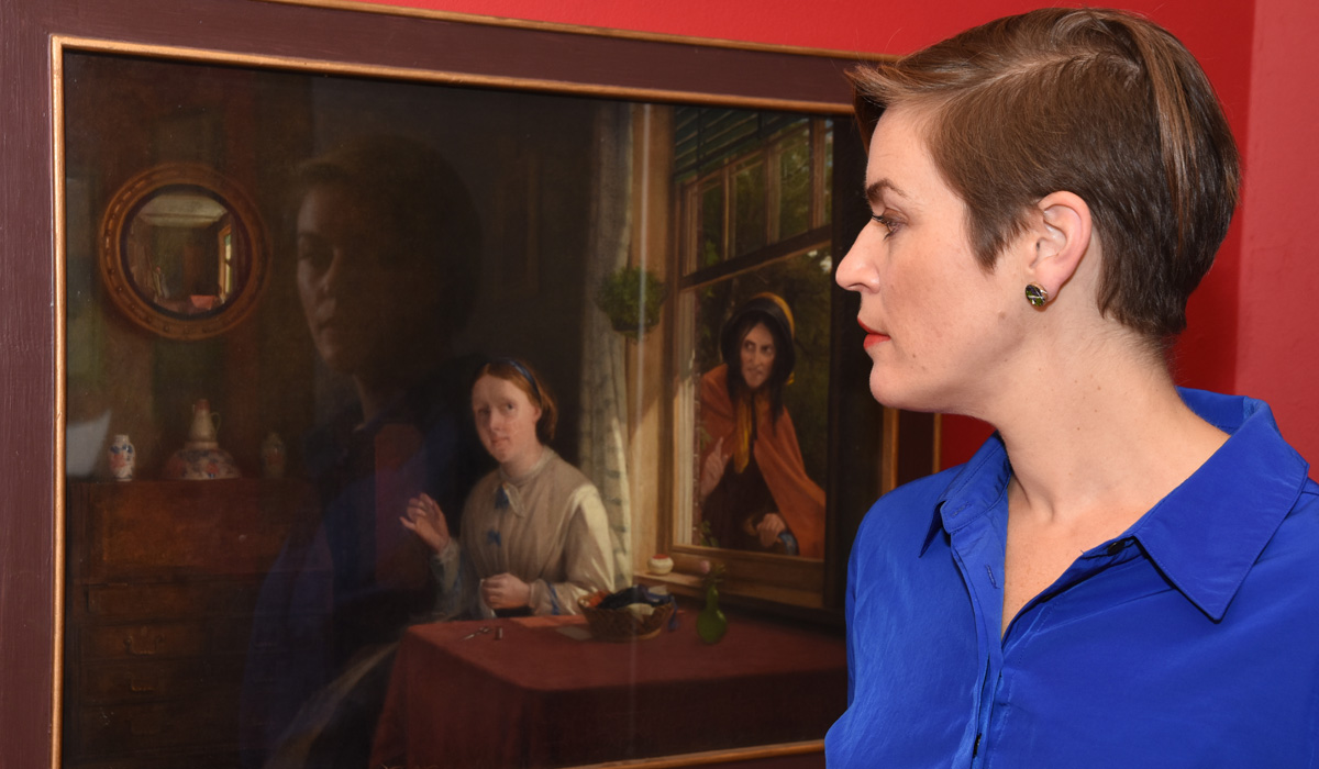 Dr Jodie Matthews looking at the painting 'The Gypsy Woman'