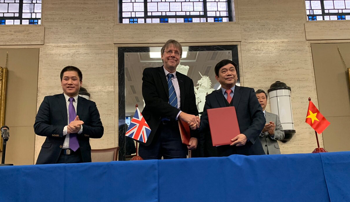 The Huddersfield Business School’s Professor John Anchor (centre) is pictured shaking hands with the NEU President, Professor Tran Tho Dat (right).