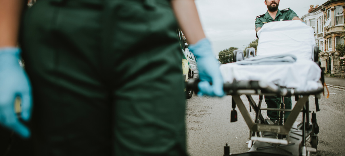 ambulance staff wheeling patient on a trolley