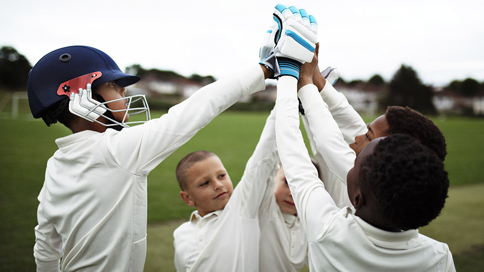 Some children high five playing cricket
