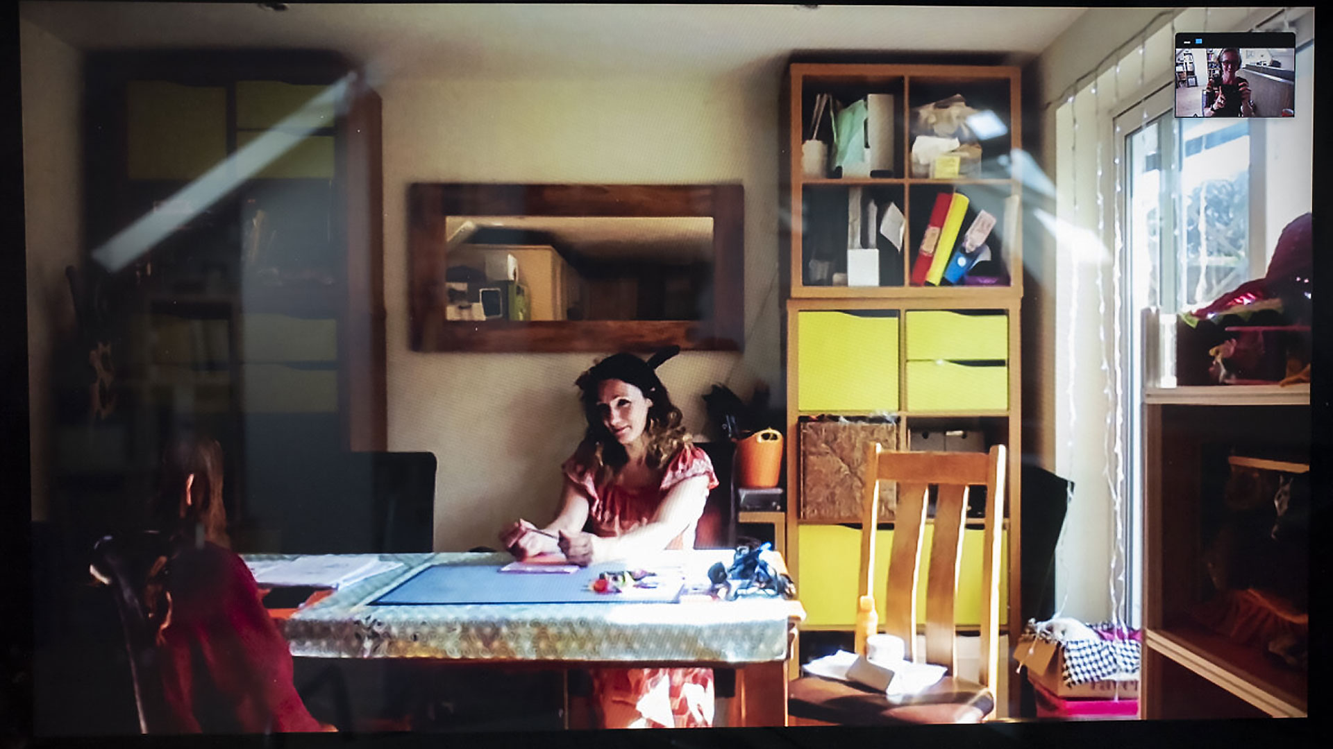 Bianca sitting at the kitchen table with her middle daughter in the sunlight.