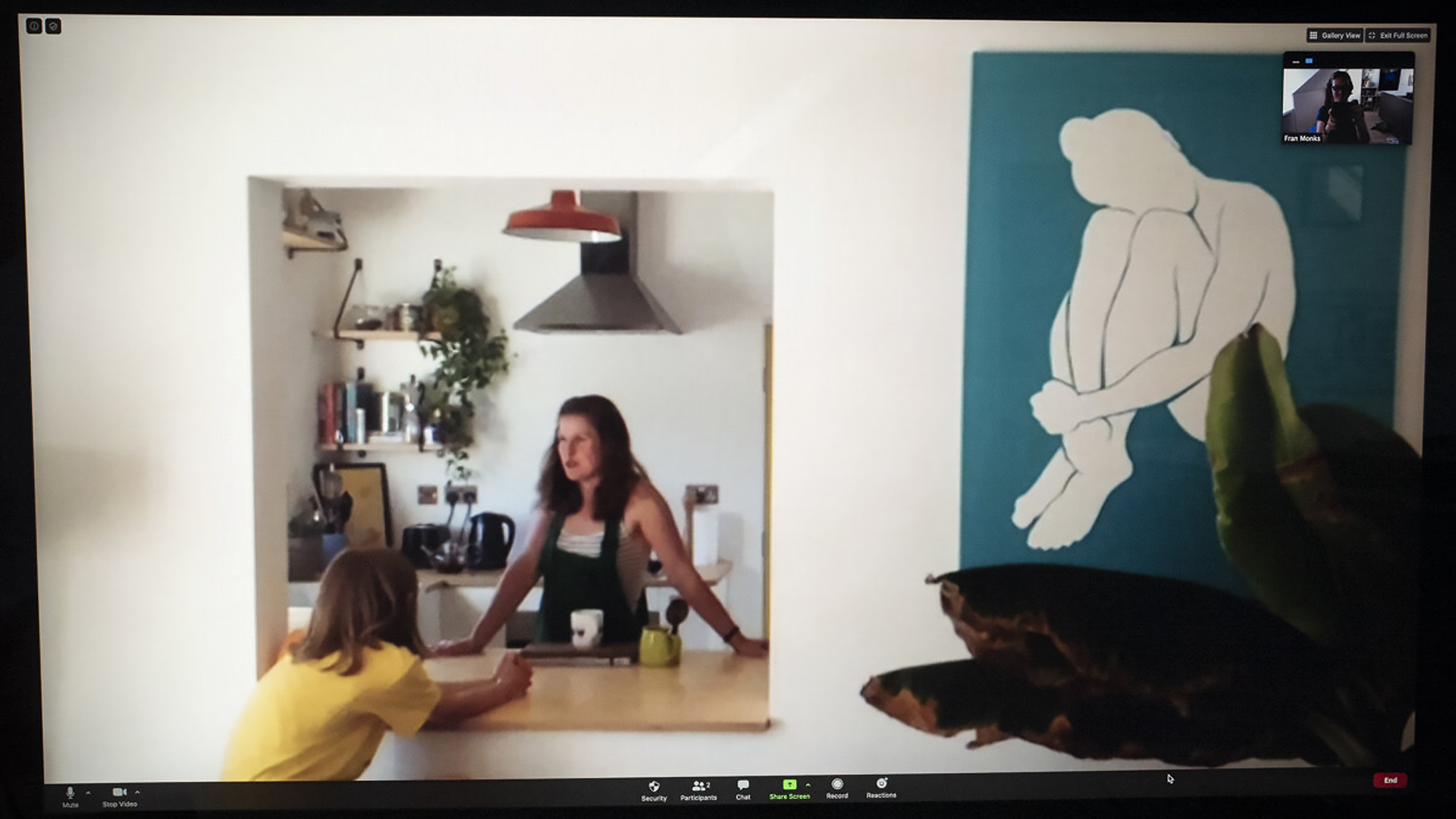 Charlotte talks to her stepson through a hatch to the kitchen. On the right is a blue and white painting of a person painted by Charlotte.