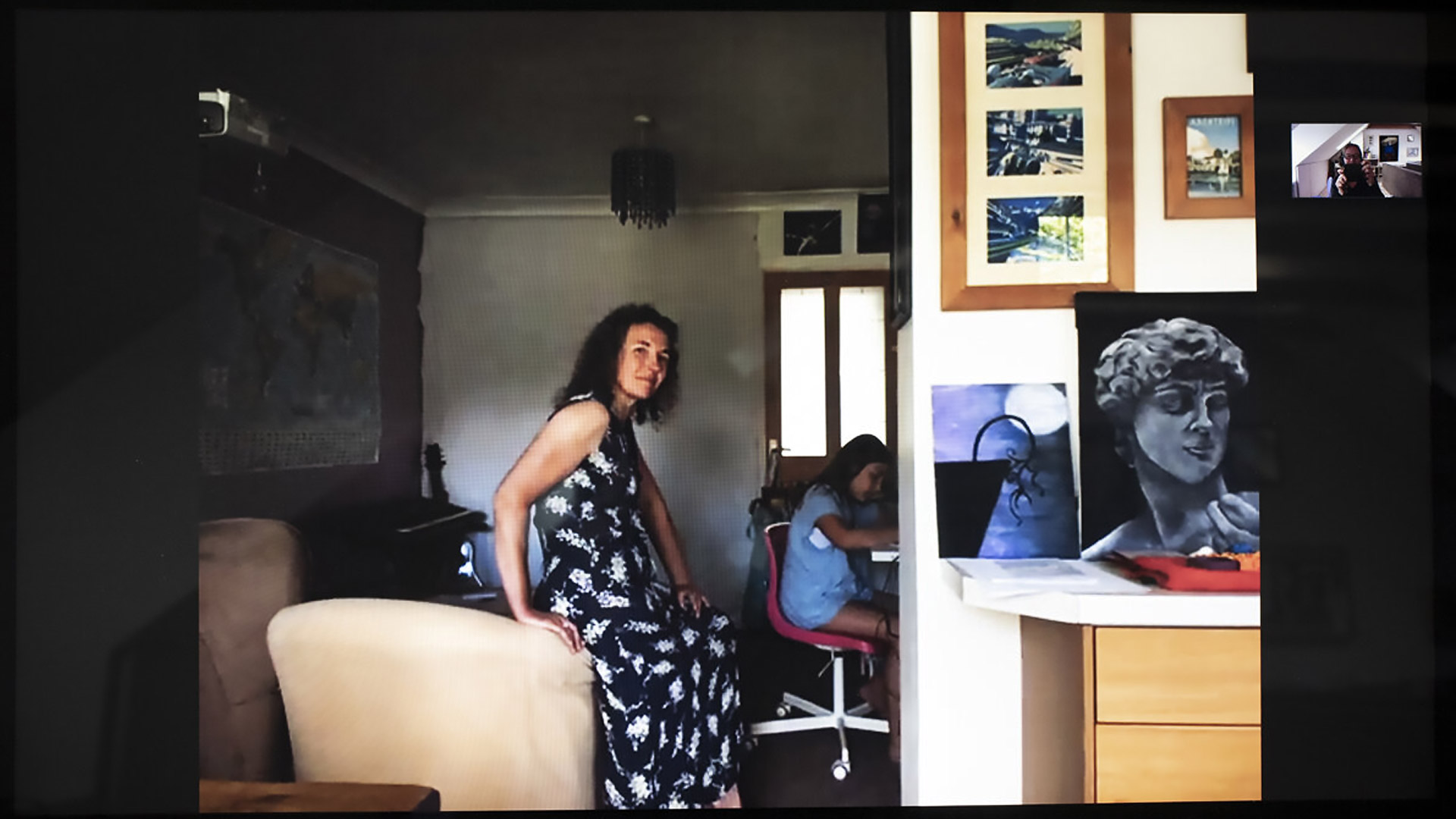 Kathryn perches on an armchair whilst checking in with her daughter working at the desk