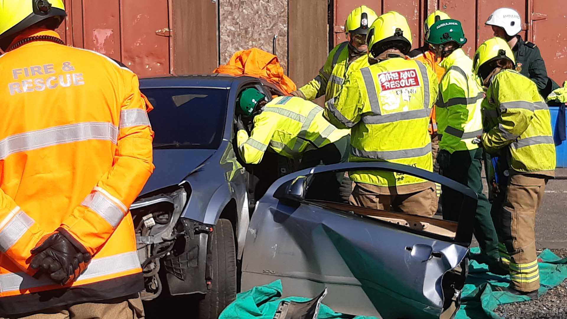 Student paramedics working around a wrecked car