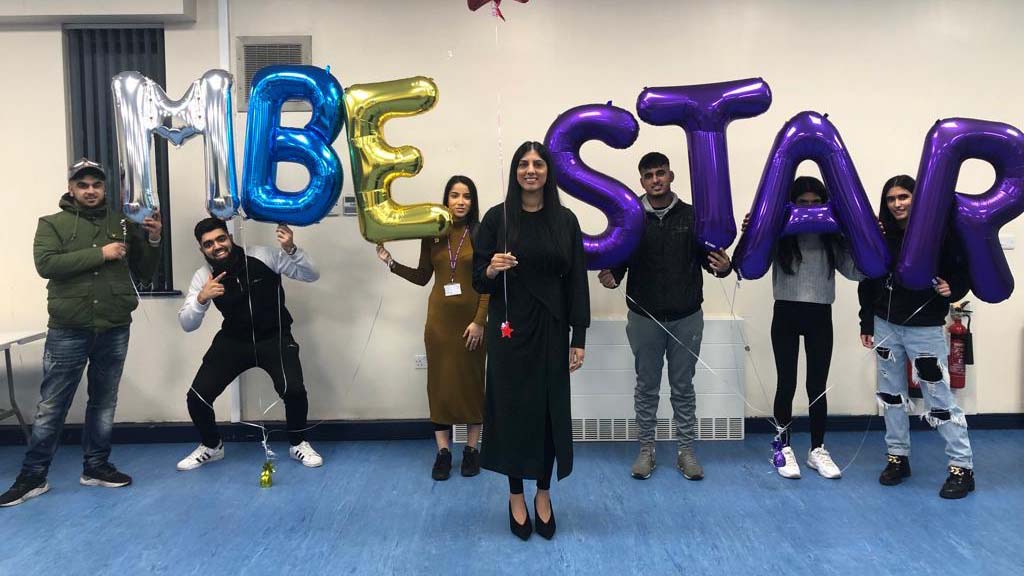 Sofia Buncy with some young adults celebrating her MBE with balloons