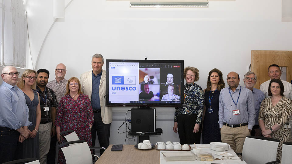 UNESCO team members stood in front of a screen