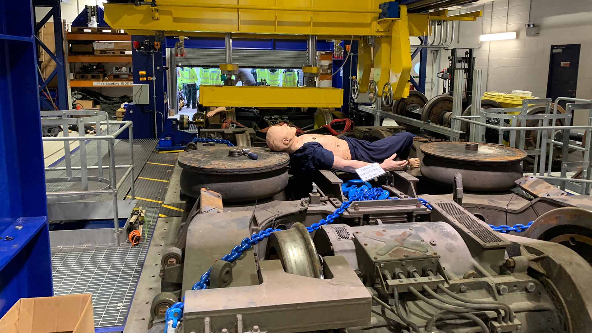 An injury mannequin lies across some railway equipment