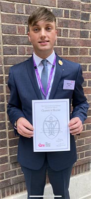 Matthew Cain with an award certificate
