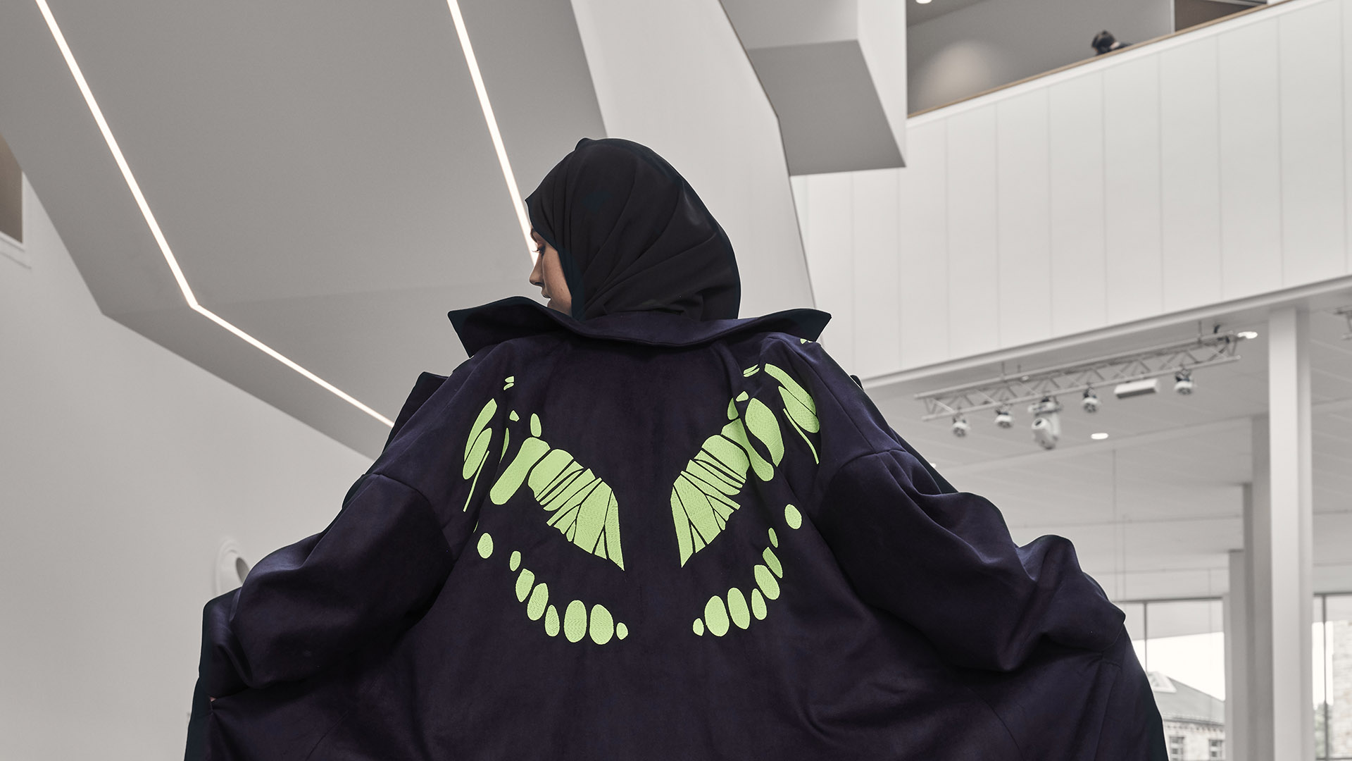 A female model showing the back of her butterfly design outfit with a butterfly showing to camera