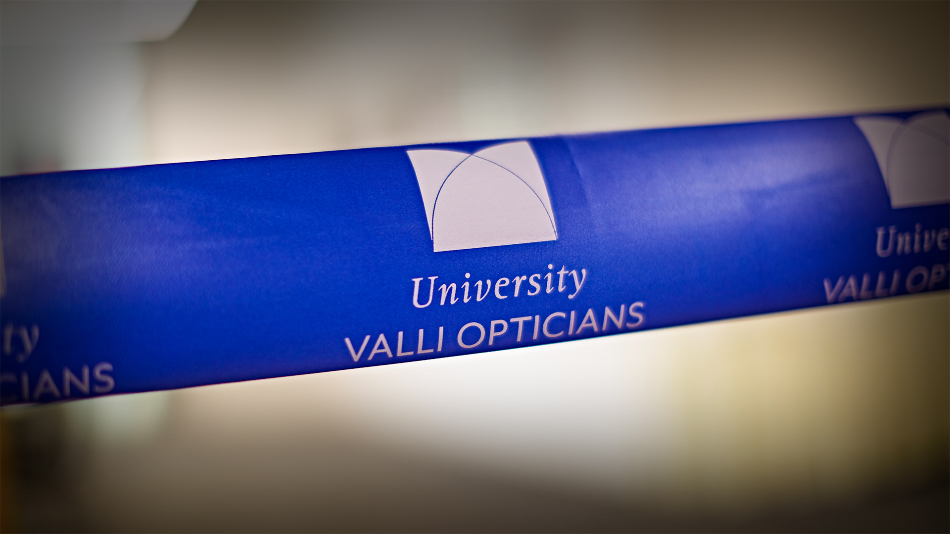 The ribbon displaying the University Valli Opticians logo at the official opening of the new eye clinic