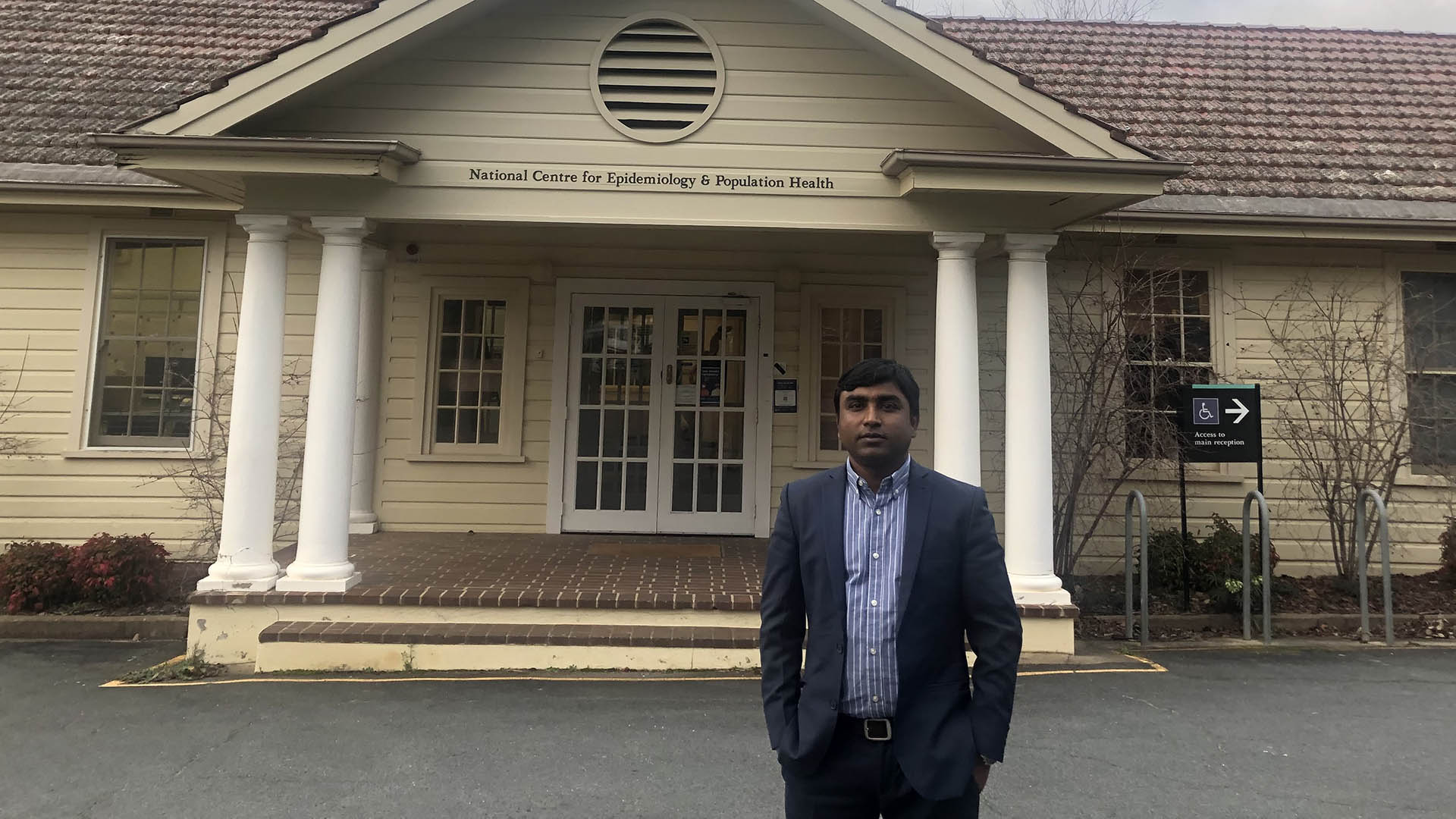 Devendra Singh in front of a building