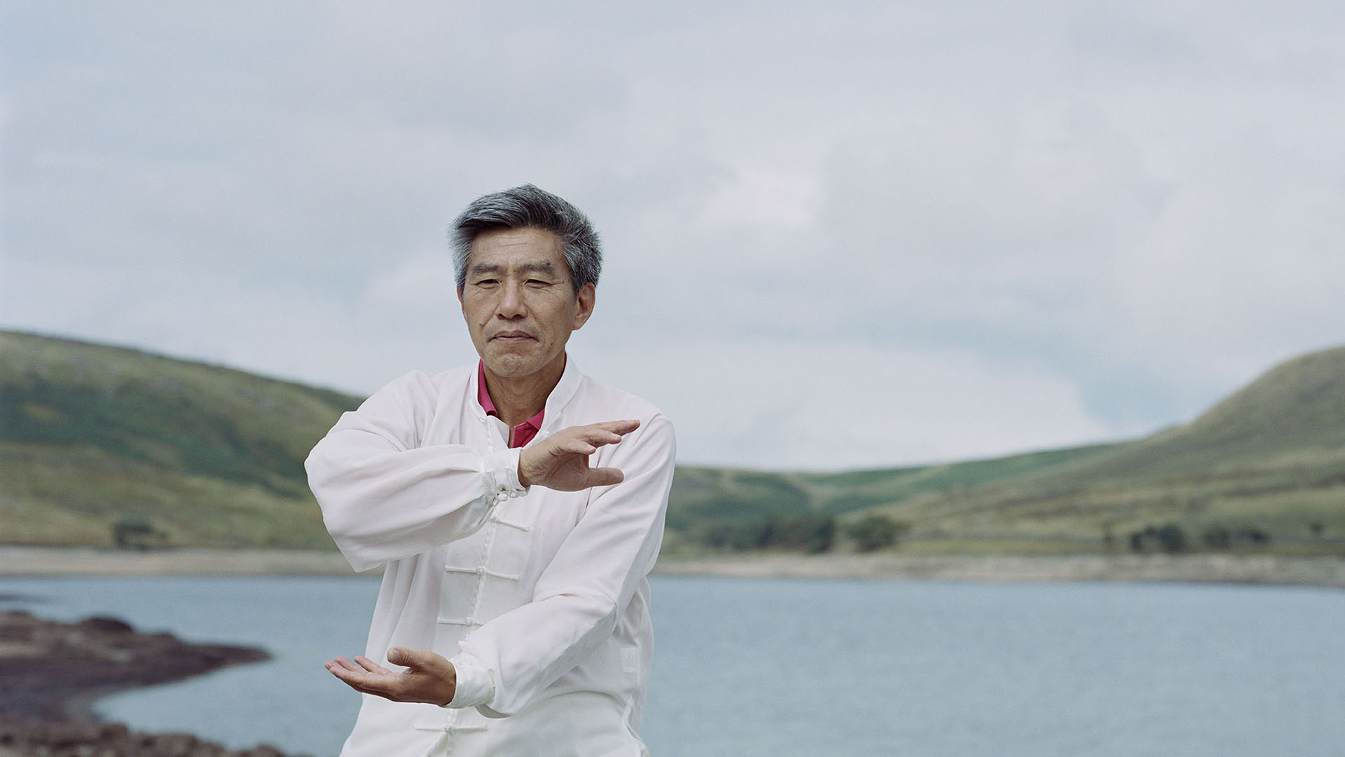 A British Chinese man does tai chi by a reservoir in West Yorkshire