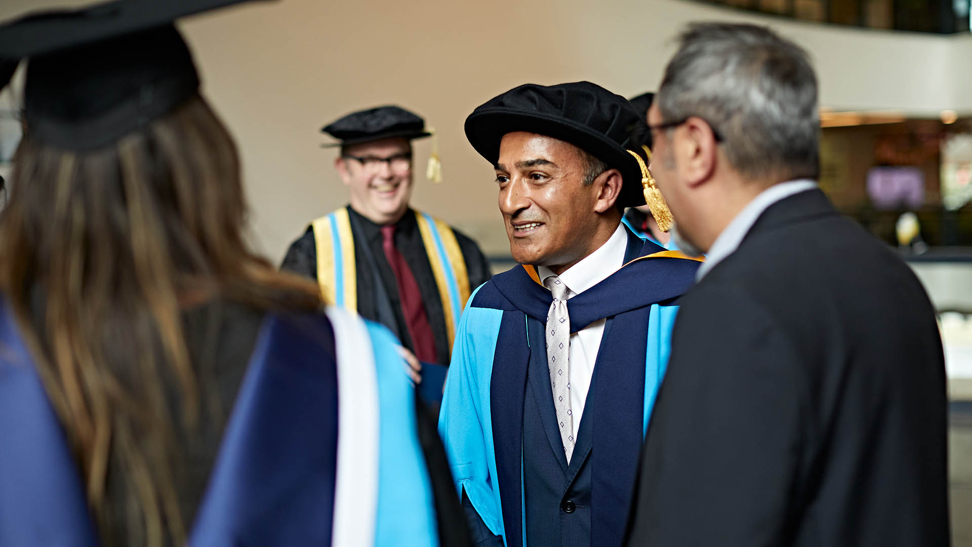 Adil Ray speaks to people after his honorary doctorate