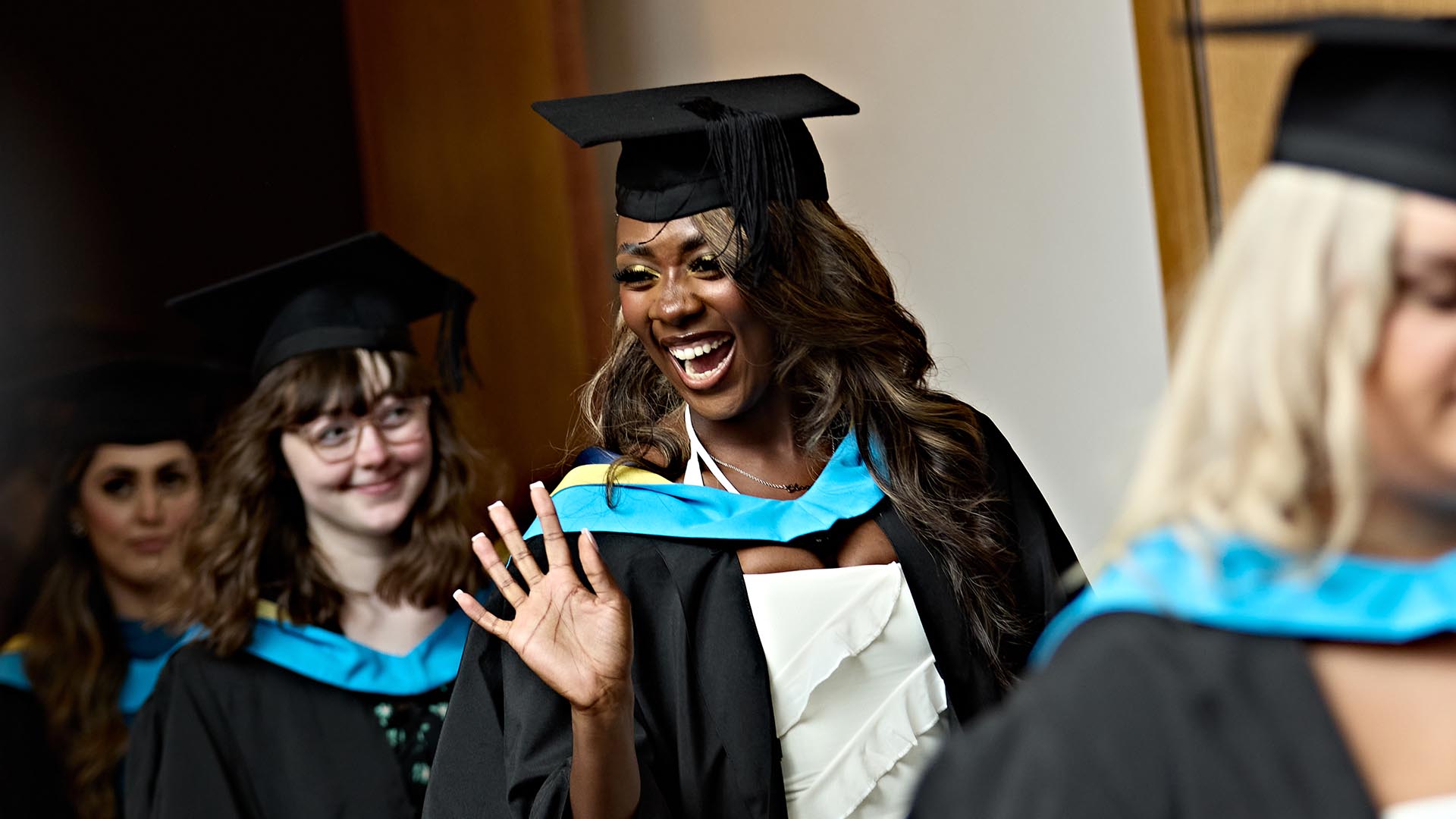 A happy student waves at someone