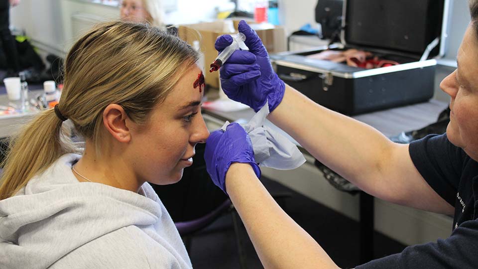 Student has injury makeup applied