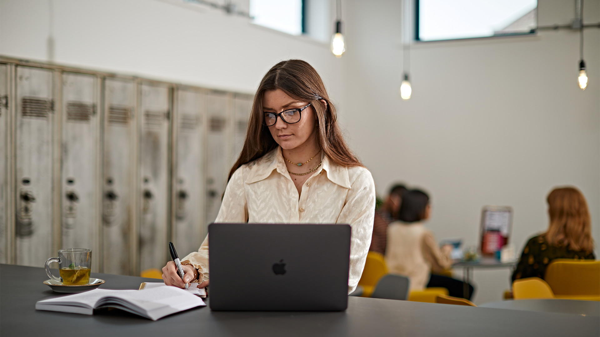 a student sitting in a coffee shop using a laptop