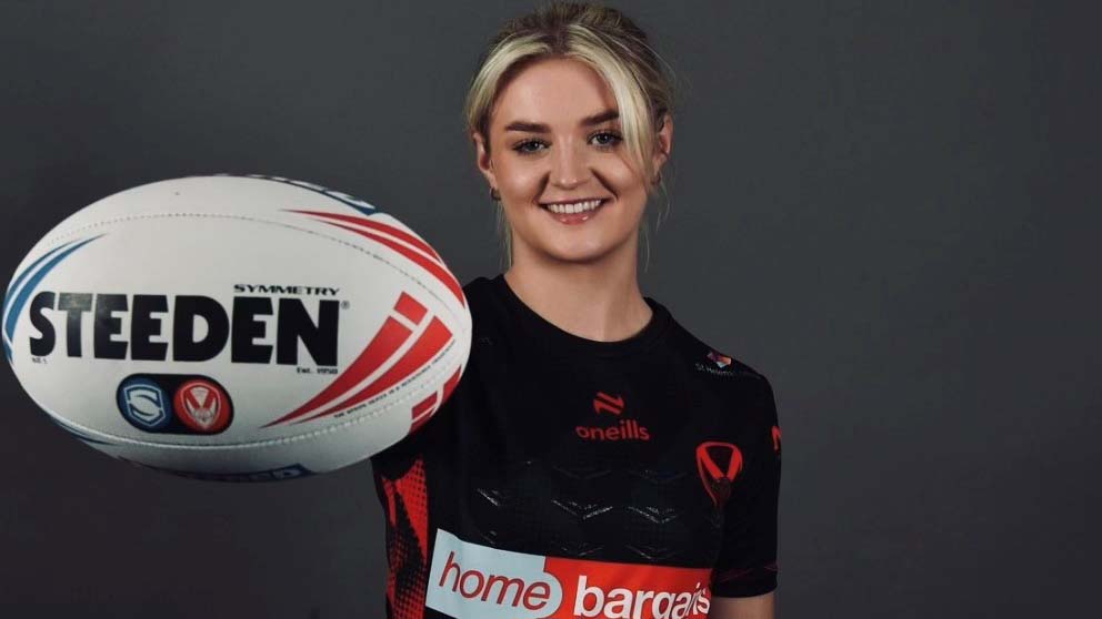 Erin Stott holds a rugby ball to the camera