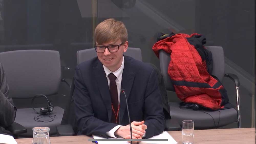 Tom Simcock speaks to the Welsh inquiry sat at a desk