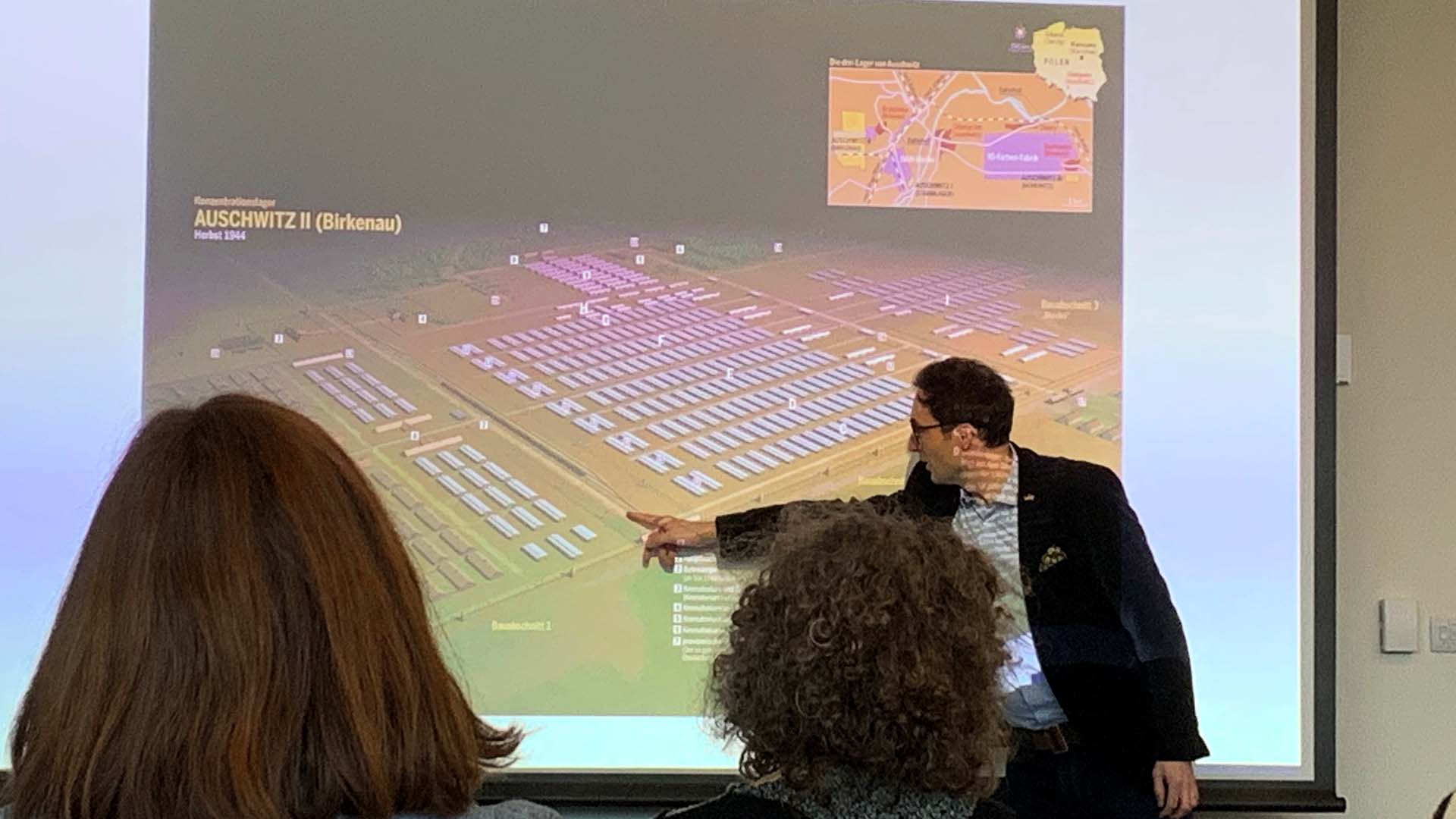 Dr Stefan Hördler speaks to students while stood in front of a screen