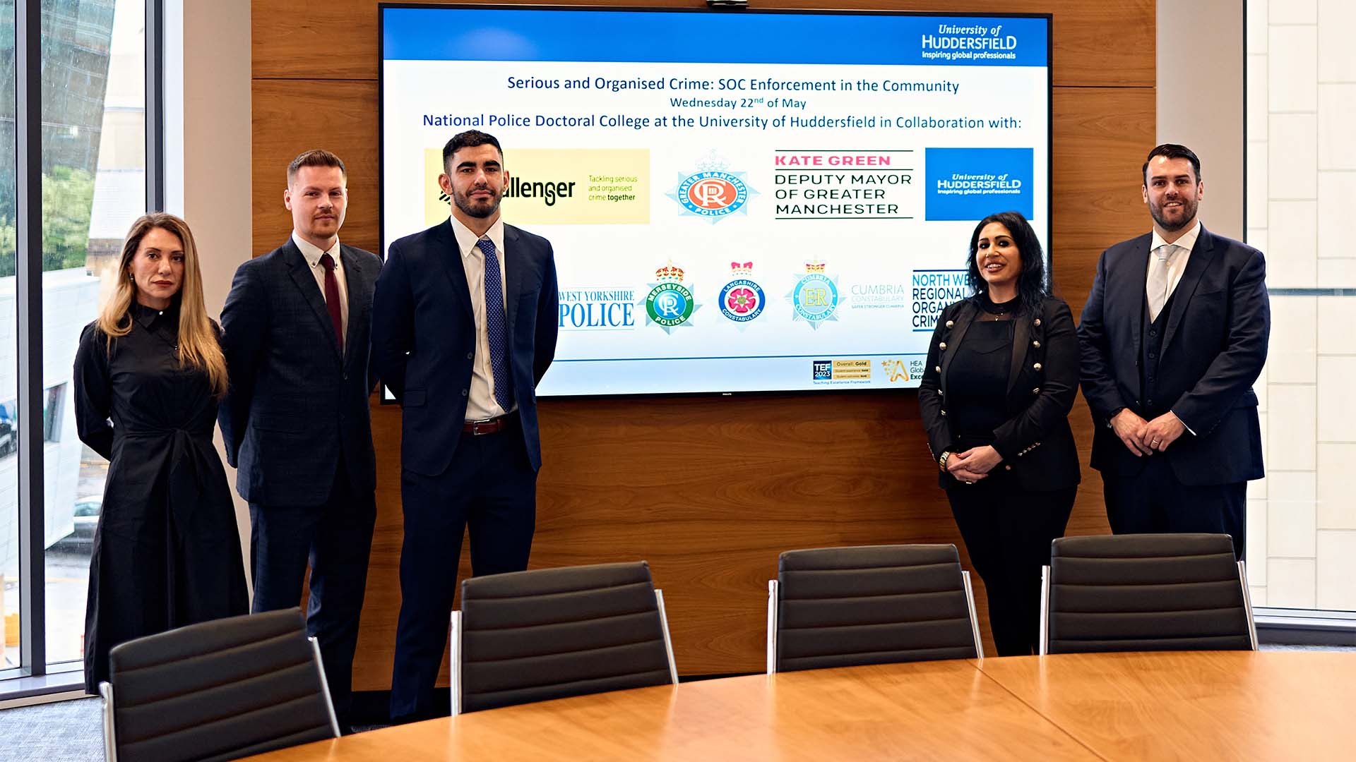 Delegates at a policing conference stood in front of a screen