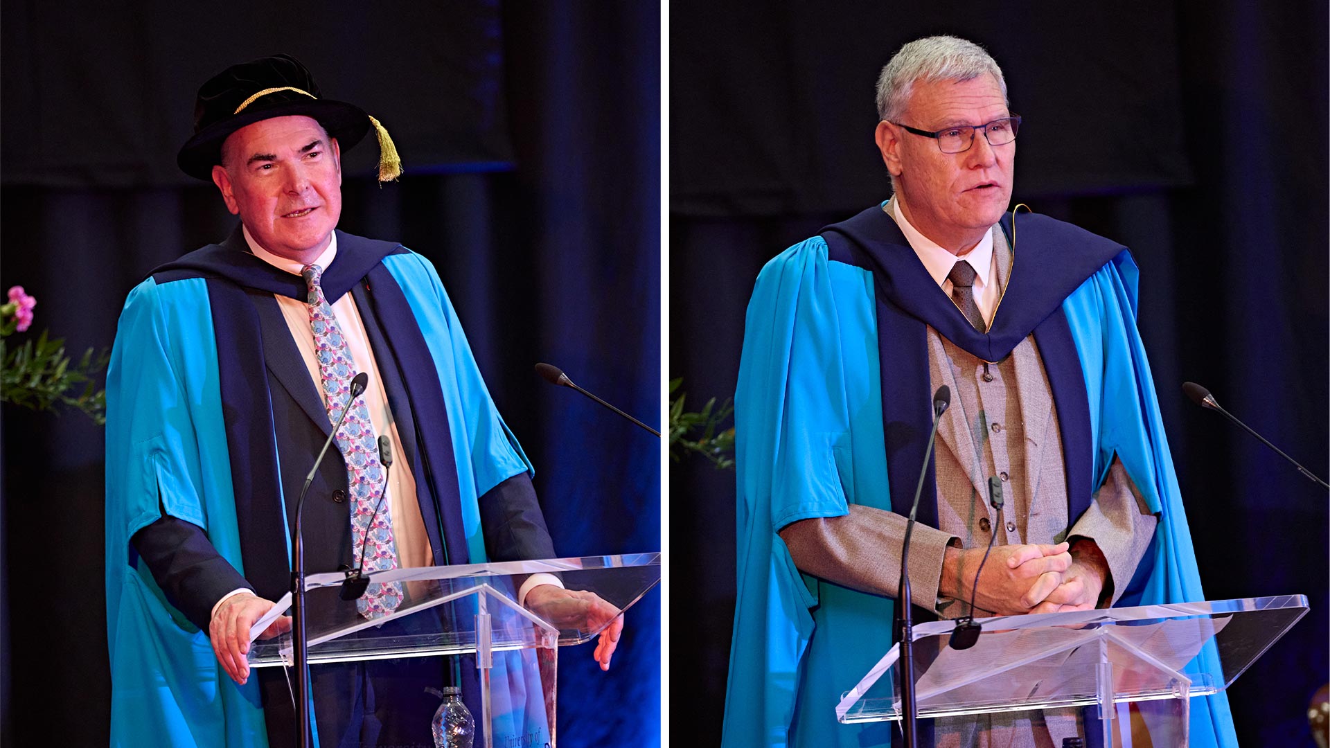 Two men at a podium wearing graduation gowns